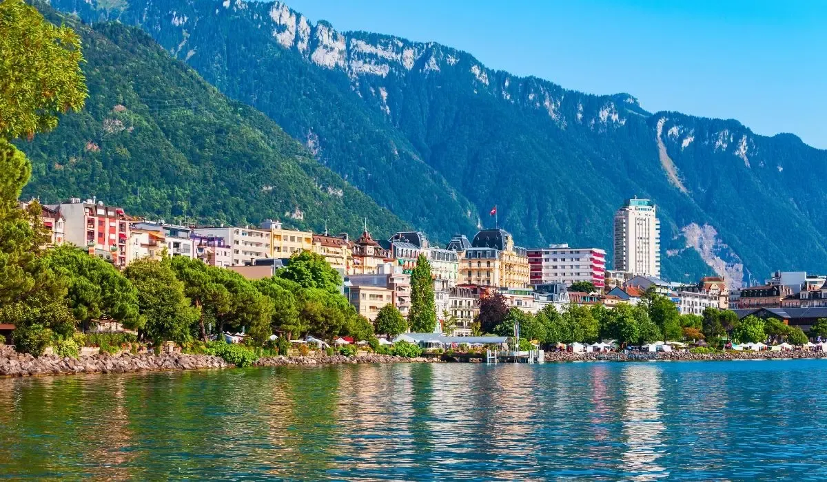  A panoramic view of Lucerne, Switzerland, showcasing the Chapel Bridge over Lake Lucerne with the Swiss Alps in the background.