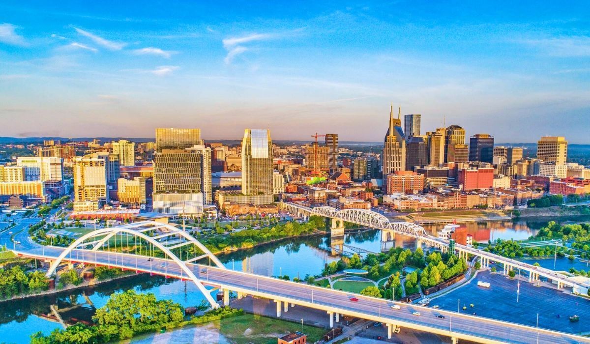 Aerial view of downtown Nashville, Tennessee, featuring iconic skyline and bridges over the Cumberland River.