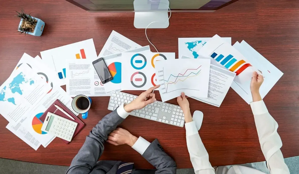 Business professionals analyzing global financial data and payment trends at a desk.