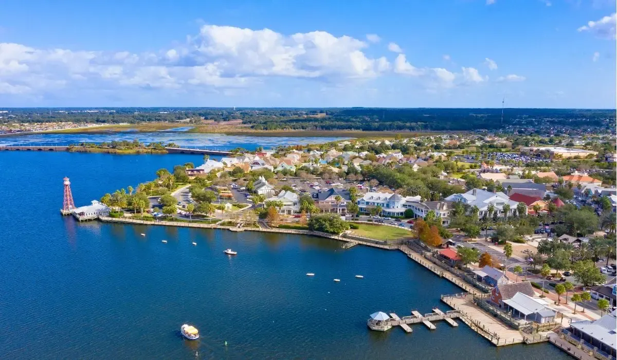 A community scene from The Villages, Florida, depicting golf carts on tree-lined streets and residents enjoying outdoor activities.