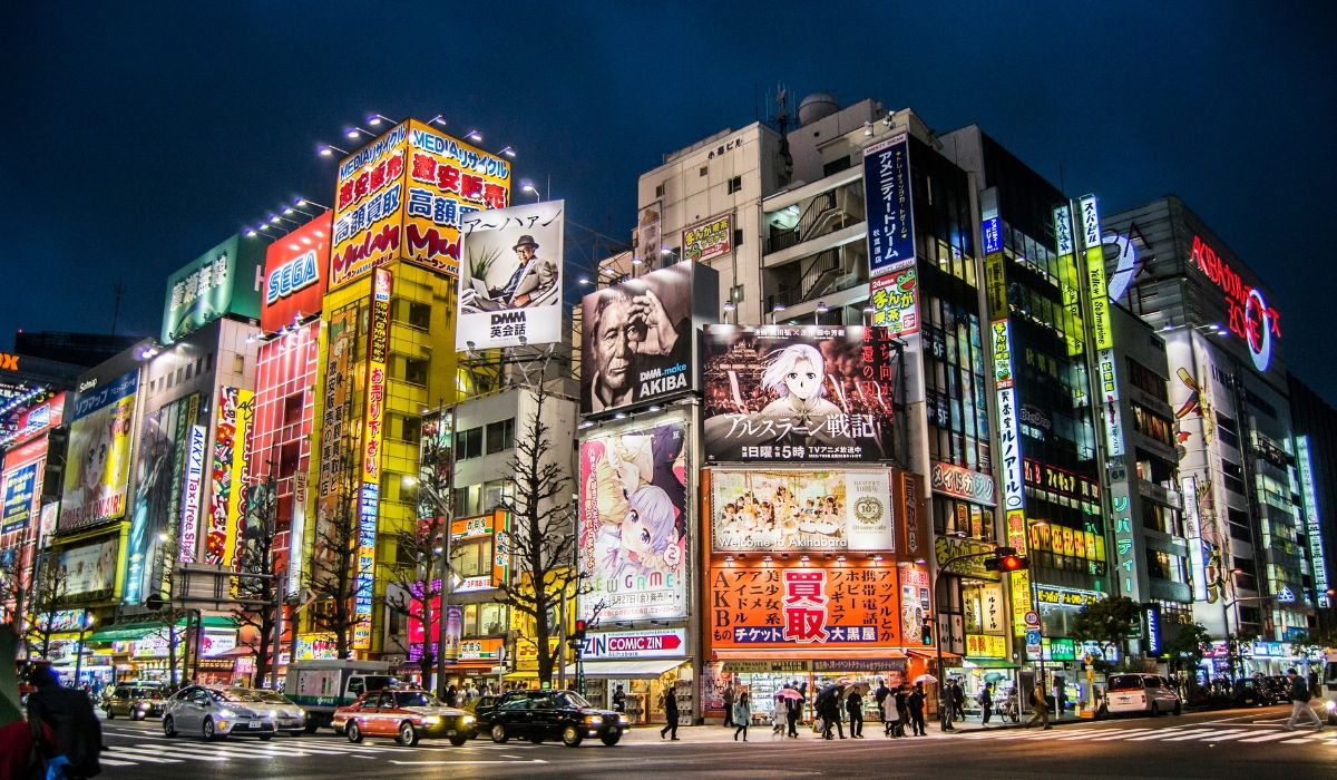 Lively night scene in Tokyo’s Akihabara district filled with neon lights, anime billboards, and bustling street activity