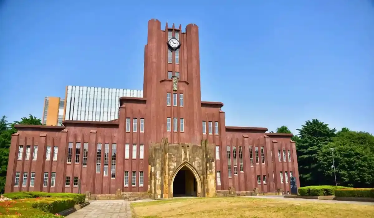 Red-brick building of the University of Tokyo featuring a central clock tower and arched entrance, set against a clear blue sky