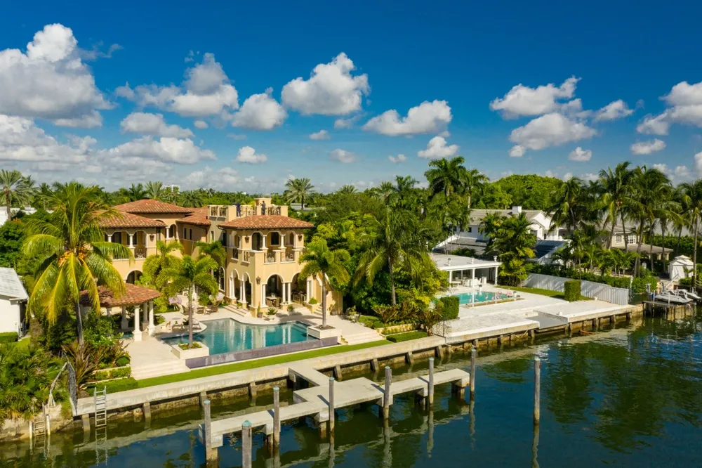 Luxury waterfront home with a private dock and swimming pool in a prestigious coastal neighborhood in the United States.