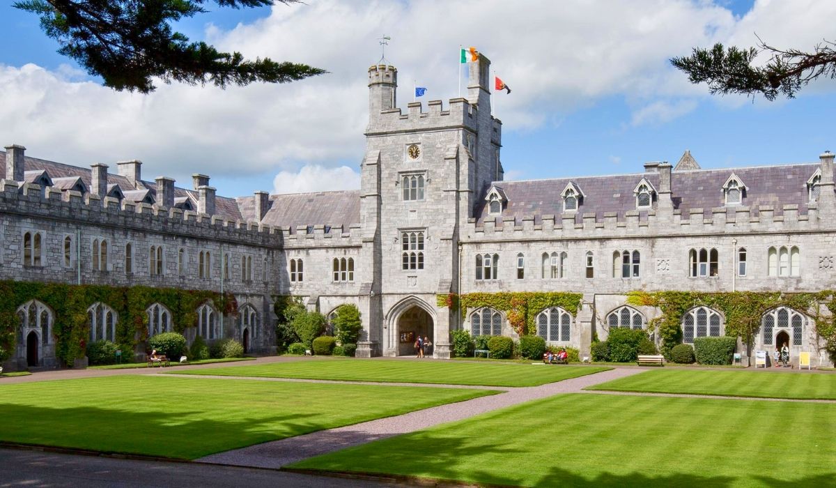 The historic quadrangle of University College Cork, featuring Gothic-style stone buildings and a well-manicured lawn.