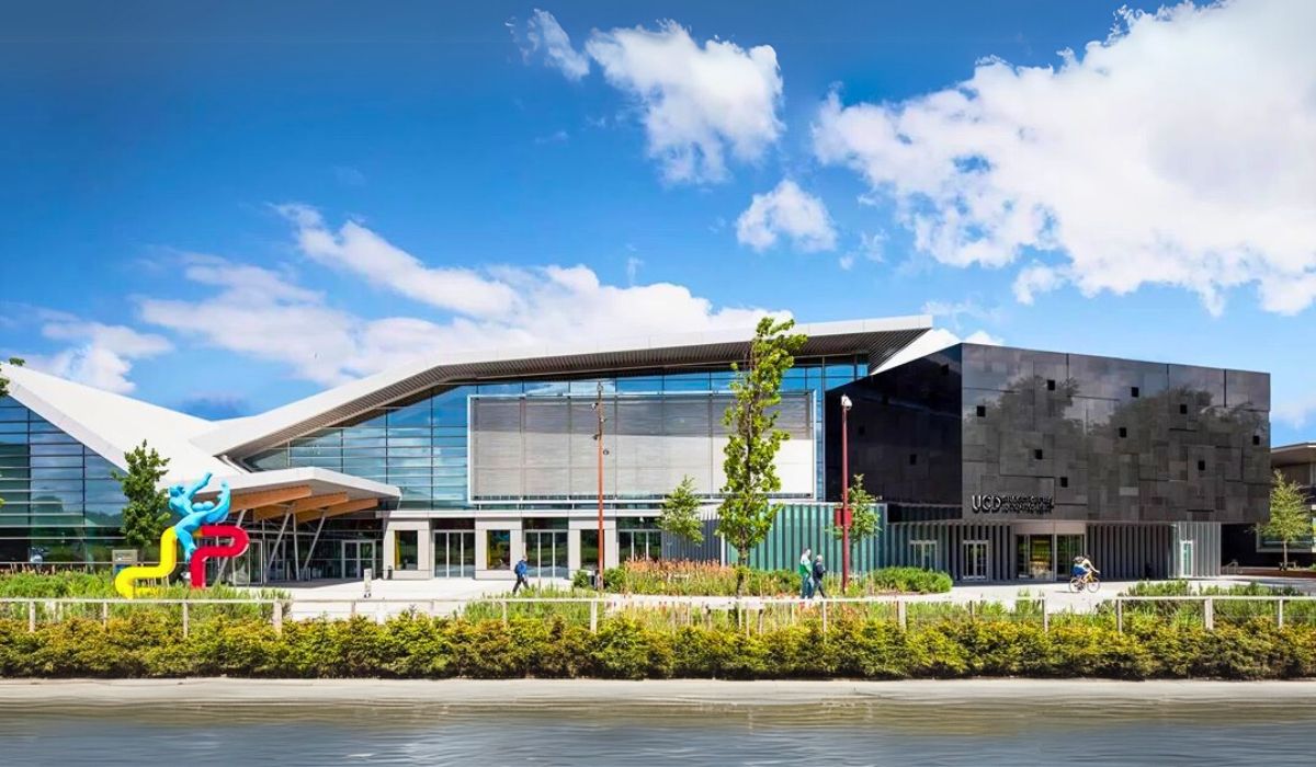 A modern architectural view of University College Dublin's campus, highlighting contemporary buildings set amidst landscaped gardens and walking paths.