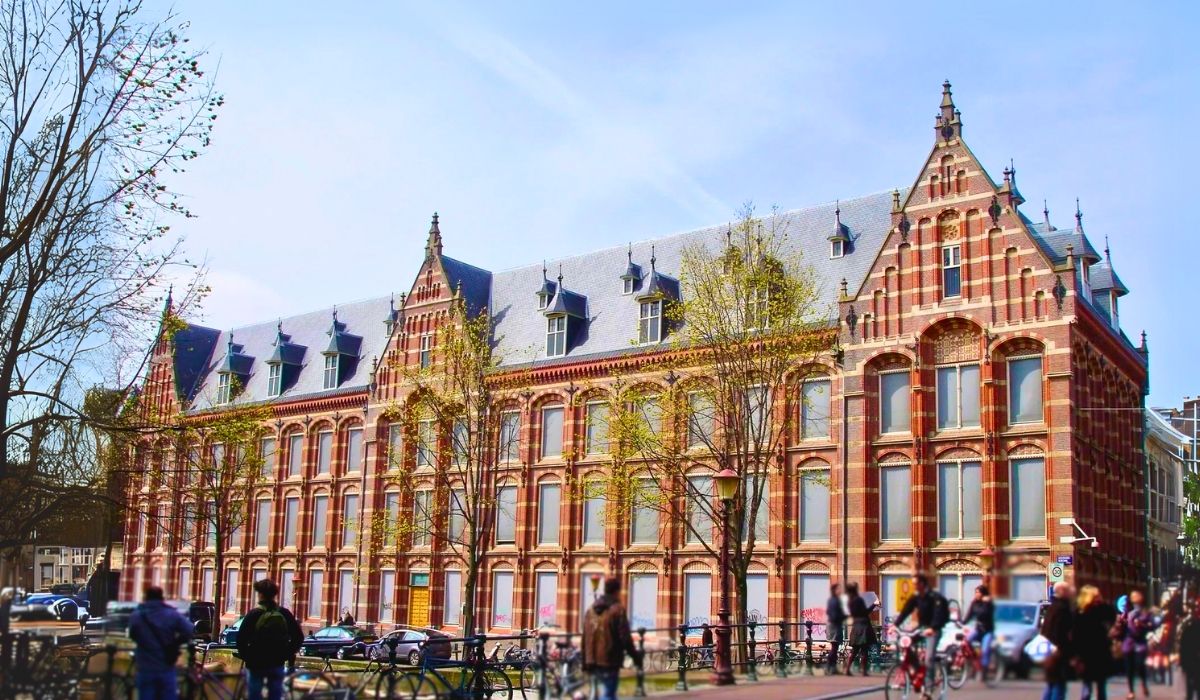 A view of the University of Amsterdam's historic campus buildings, with students on bicycles,reflecting the city's academic and cycling culture.