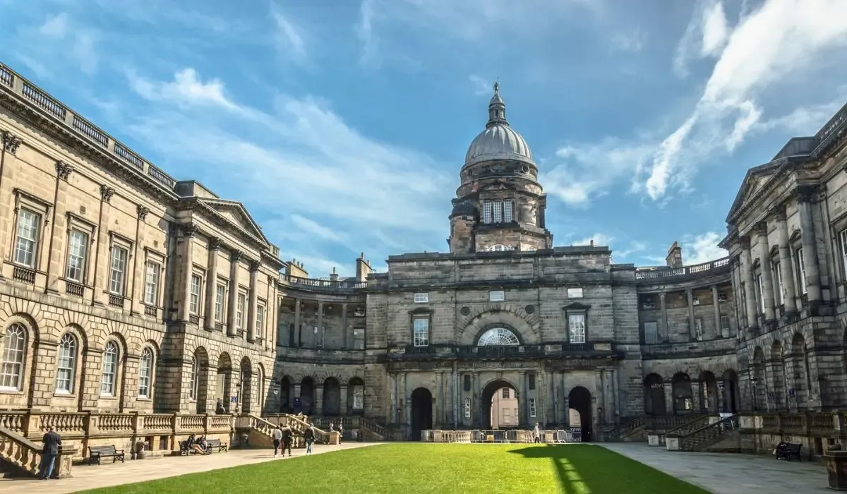 A wide-angle shot of the University of Edinburgh’s Old College courtyard with classical stone architecture and a cloudy sky.