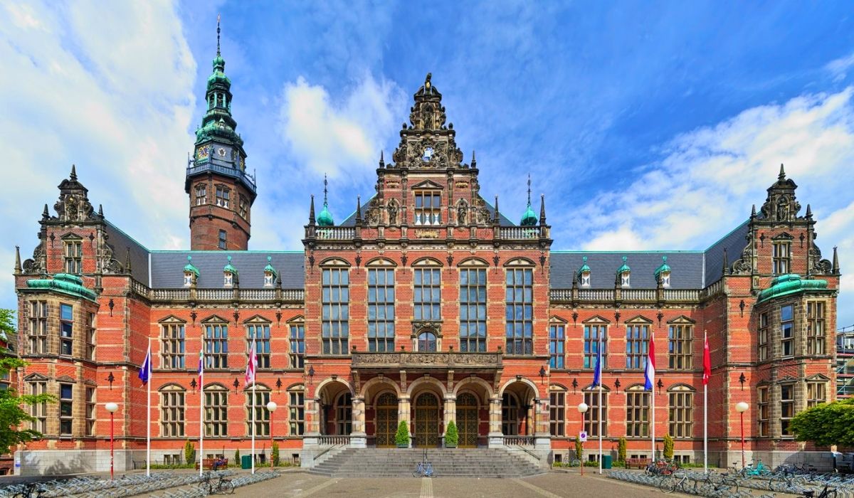 A photograph of the University of Groningen's central square, featuring the iconic Academy Building with its ornate façade.