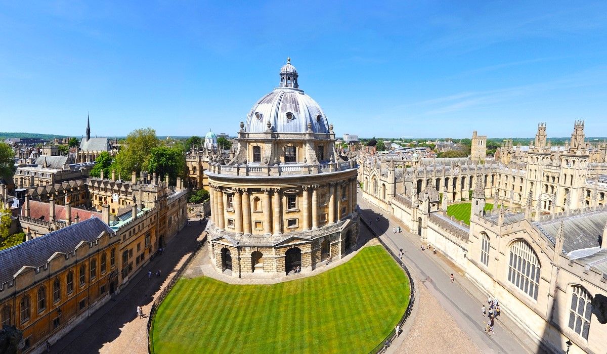 Iconic Radcliffe Camera building at the University of Oxford, United Kingdom, surrounded by historic colleges and lush green lawns.