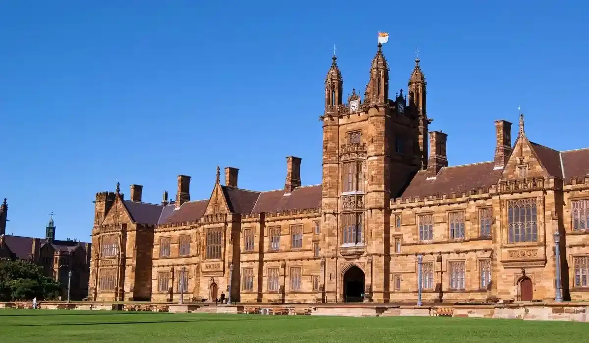 Historic sandstone architecture of the University of Sydney’s main building under a clear blue sky in Australia.