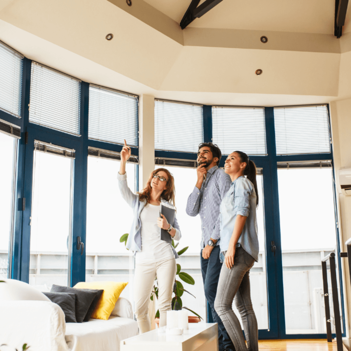 Real estate agent showing a modern home interior to a couple during a house tour