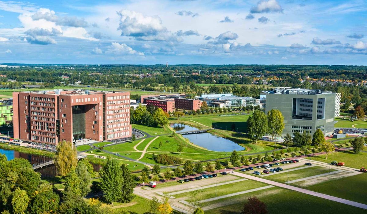A scenic view of Wageningen University's campus, surrounded by lush greenery and featuring sustainable building designs.