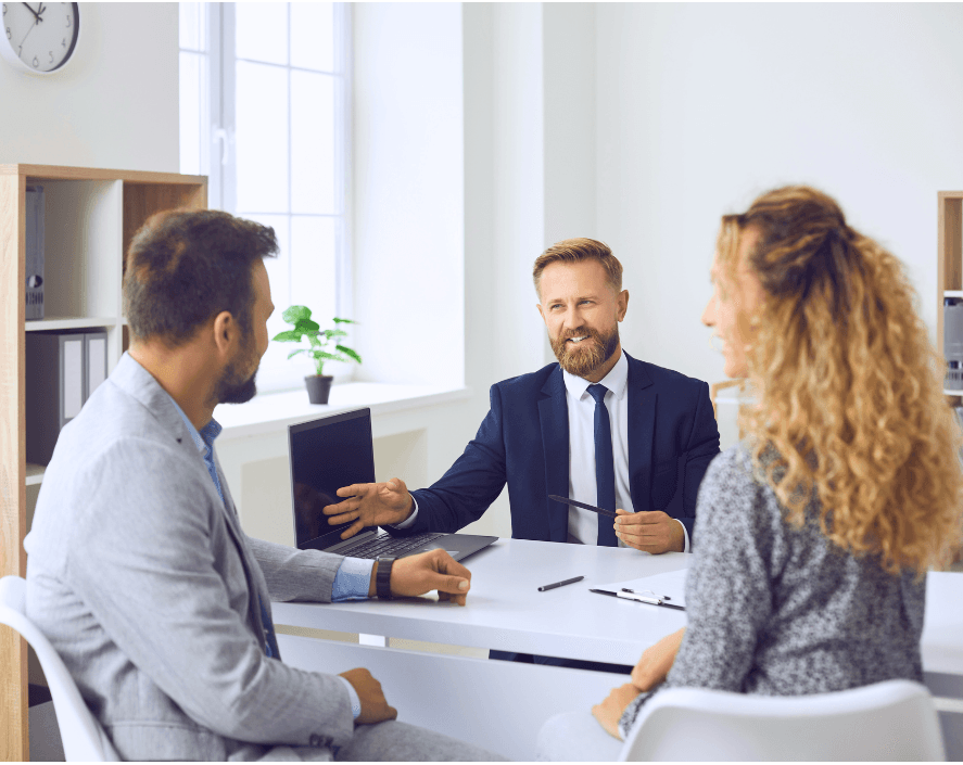 Professional advisor meeting with a couple in an office setting, discussing inheritance or financial planning.