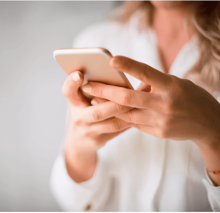 Close-up of a woman using a smartphone in a light-colored blouse