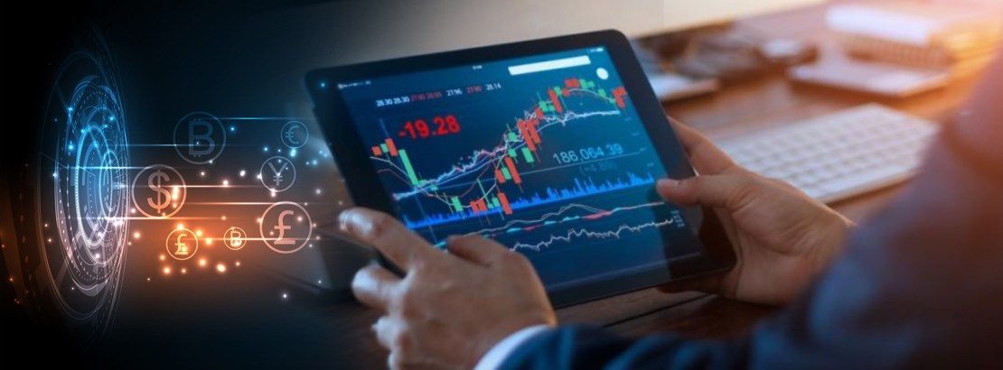 Hands holding a tablet displaying fluctuating financial charts, with digital currency symbols representing global exchange rates in the background.