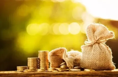 Burlap money bags and coins representing international money transfers and foreign bank account deposits.