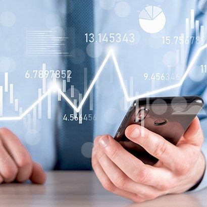 Businessman analyzing financial data on smartphone with digital graphs and currency figures overlayed, symbolizing savings on overseas money transfers.