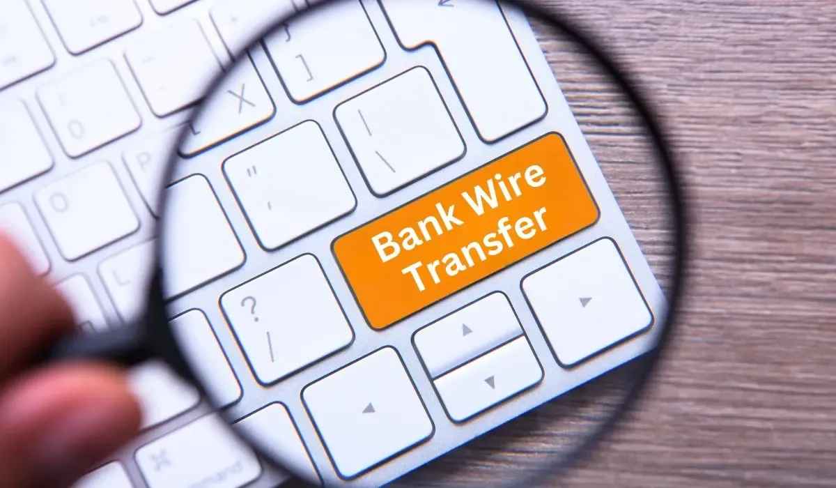 Magnified view of a keyboard with an orange “Bank Wire Transfer” button, symbolizing digital international payment options for businesses.