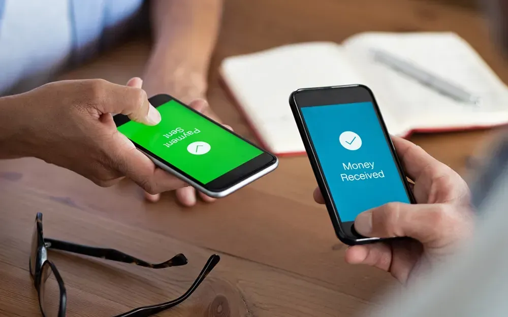 Two smartphones showing a completed international money transfer, with one screen reading 'Payment Sent' and the other reading 'Money Received.'