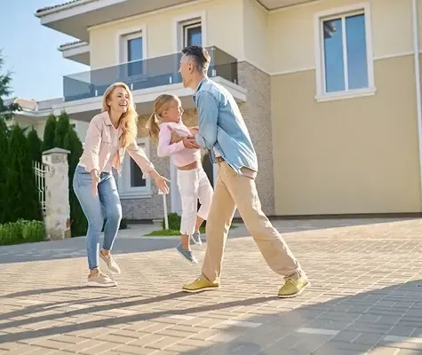 Happy family playing together outside their new home on a sunny day, symbolizing inheritance or property transfer.