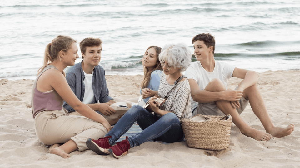 Group of friends relaxing on a beach, representing Canadian snowbirds enjoying time in the US during winter months.