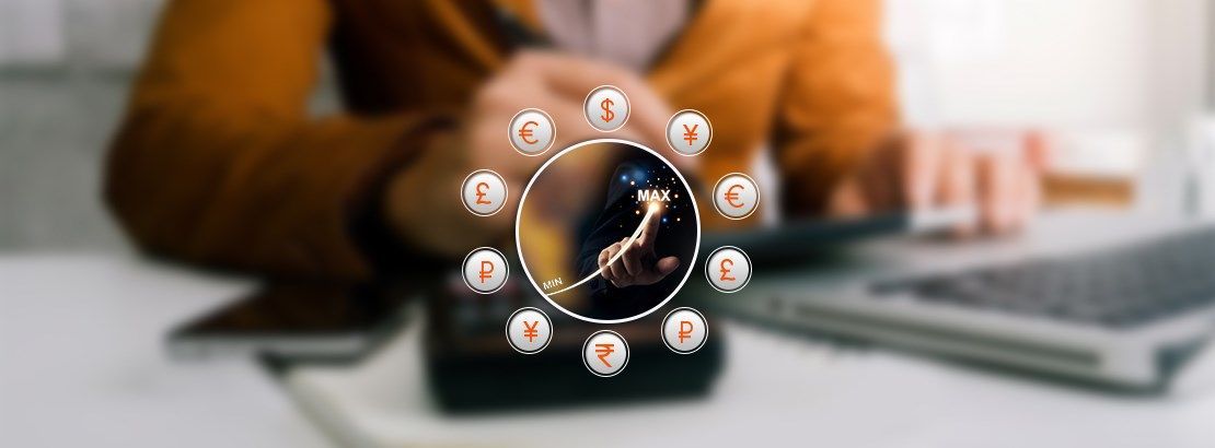 Person using calculator and tablet beside a laptop, with global currency symbols representing exchange rate optimization and saving on currency conversion fees.