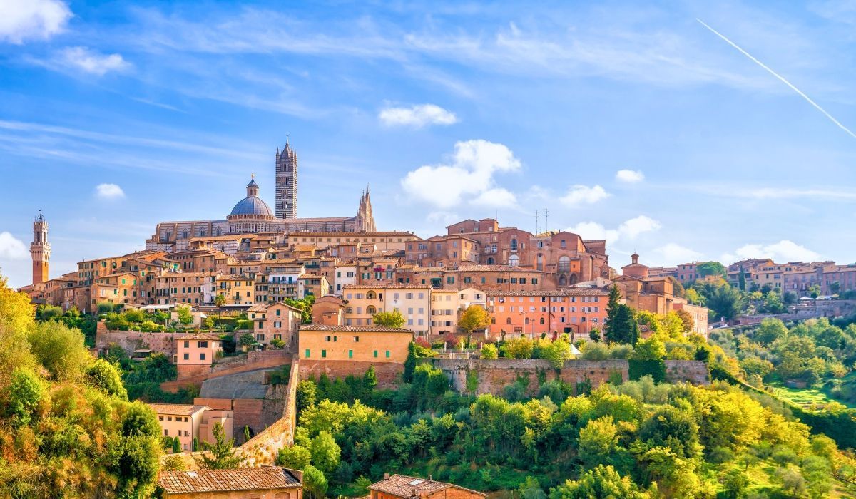 Panoramic view of Siena, Italy with its medieval architecture and iconic cathedral on a hill.
