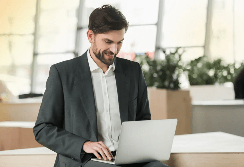 Canadian business owner reviewing GBP payments on a laptop using a multi-currency account to avoid currency conversion fees.