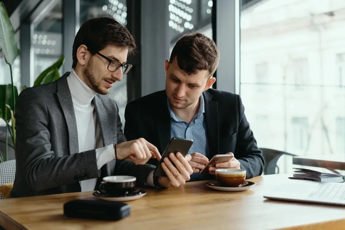 two-businessmen-having-conversation-using-smartphone