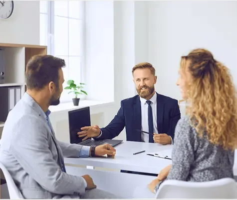 Professional advisor meeting with a couple in an office setting, discussing inheritance or financial planning.