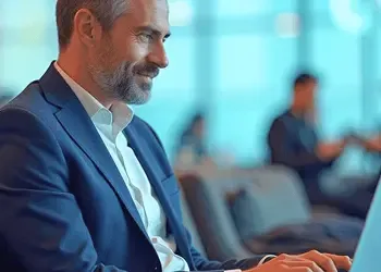 Business professional working on a laptop at an airport lounge, managing international finances remotely.